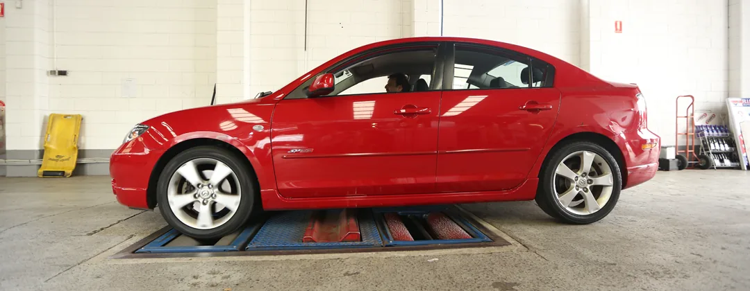 A red car inside the Pro Paint 'n Panel workshop.